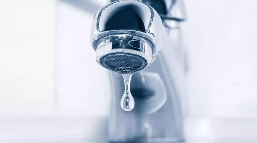 Water dripping from a chrome faucet