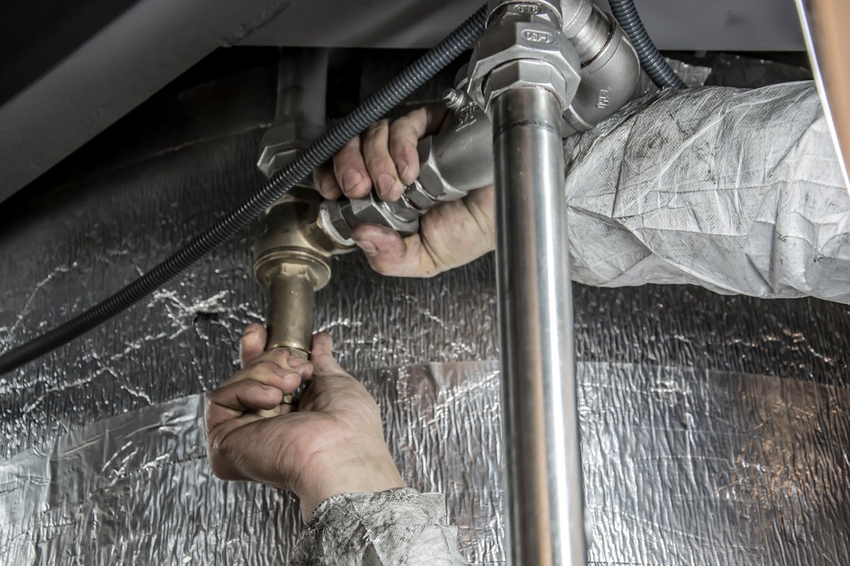 Plumber tightening a fitting on a water supply line