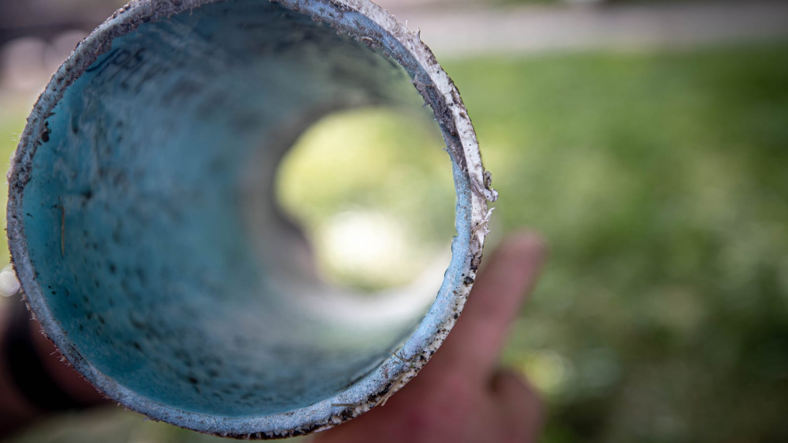 CIPP pipe liner being fed into a sewer cleanout for trenchless repair